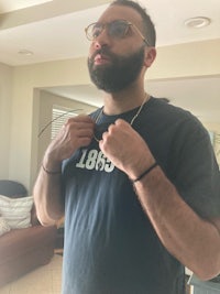 a man with a beard and glasses is standing in a living room