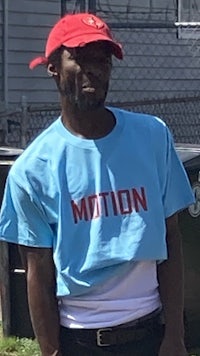 a man wearing a red hat and blue t - shirt